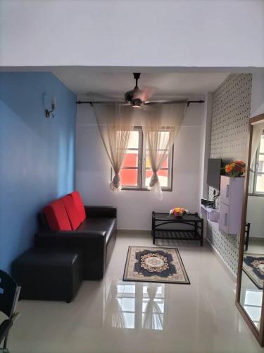 uma sala de estar com um sofá preto e uma janela em yaakub homestay seberang jaya em Kampong Belah Dua