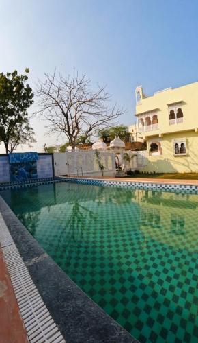 een zwembad voor een huis bij Marcol a countryside villa in Udaipur