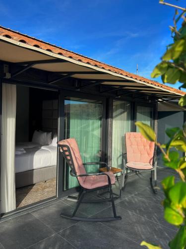 two chairs and a glass table on a patio at Chateau Mephis Kalaki in Akhalkʼalakʼi