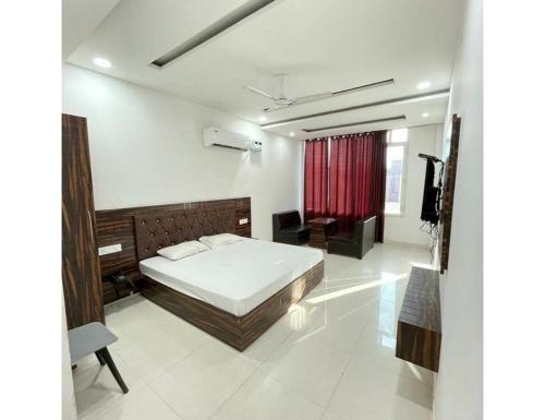 um quarto com uma cama e uma cortina vermelha em Town house cafe and hotel, Kurukshetra em Kurukshetra