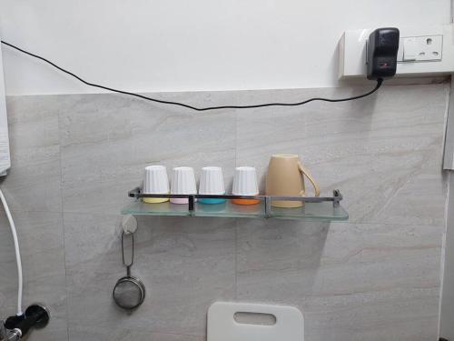 a shelf on the wall with four cups on it at 1bhk flat Bandra in Mumbai