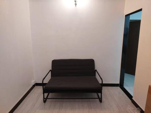a black chair in a room with a white wall at 1bhk flat Bandra in Mumbai