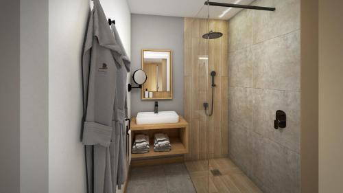 ein Bad mit einem Waschbecken, einem Spiegel und einer Dusche in der Unterkunft Papangue Hôtel & Spa in L’Étang-Salé