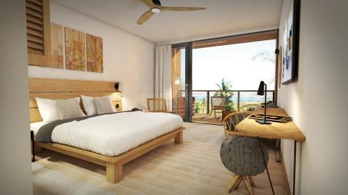 Schlafzimmer mit einem Bett, einem Schreibtisch und einem Fenster in der Unterkunft Papangue Hôtel & Spa in L’Étang-Salé