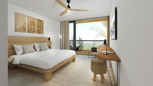 1 dormitorio con cama, escritorio y ventana en Papangue Hôtel & Spa, en Étang-Salé