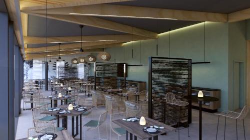 un restaurante con mesas y sillas en una habitación en Papangue Hôtel & Spa, en Étang-Salé