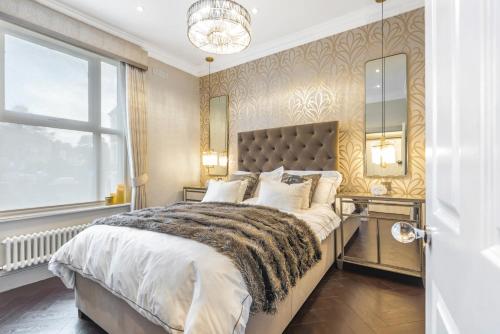 a bedroom with a large bed and a window at Luxury 1-Bed Apartment in sought after prime London location in London