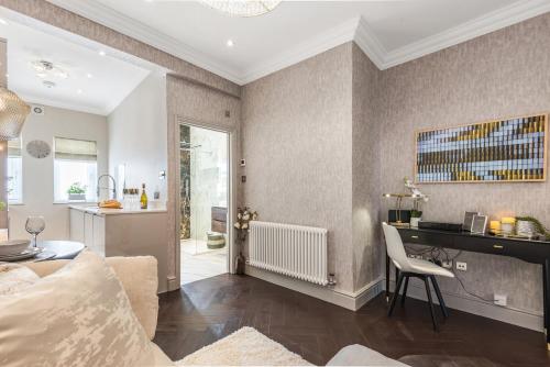 a living room with a couch and a desk in a room at Luxury 1-Bed Apartment in sought after prime London location in London