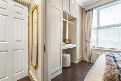 a bedroom with a white door and a window at Luxury 1-Bed Apartment in sought after prime London location in London