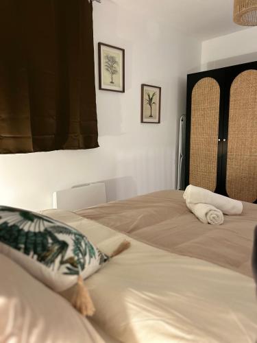 une chambre avec deux lits et deux tableaux au mur dans l'établissement LE PETIT NIORTAIS - Centre ville - WIFI - NETFLIX - AMAZON, à Niort