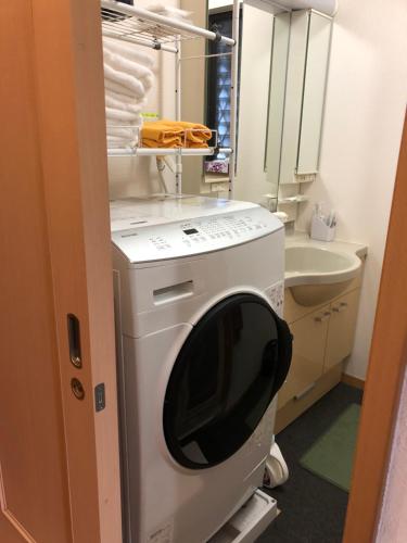 Waschmaschine und Trockner in einem kleinen Bad in der Unterkunft SUMIDA in Osaka
