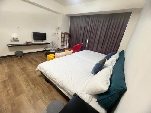 Un dormitorio con una cama grande y un televisor. en 薇楽民宿, en Nantou City