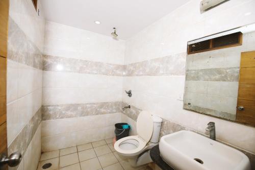 Hotel Lav-Kush في نيودلهي: حمام مع مرحاض ومغسلة
