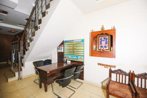 新德里的住宿－Hotel Lav-Kush，一间带木桌和椅子的用餐室