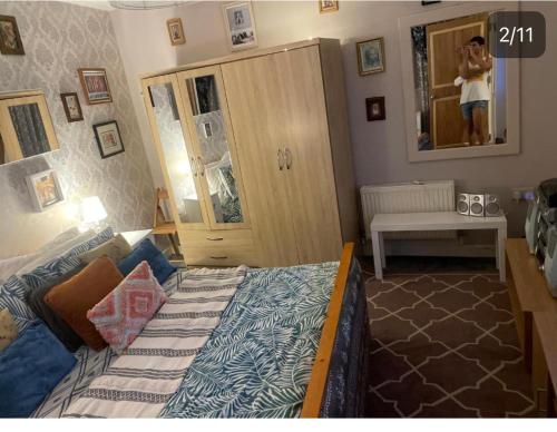a bedroom with a bed and a person in the mirror at Room in zone 2 in London