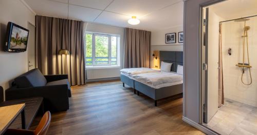 una habitación de hotel con una cama y un sofá en Go Hotel Herlev, en Herlev