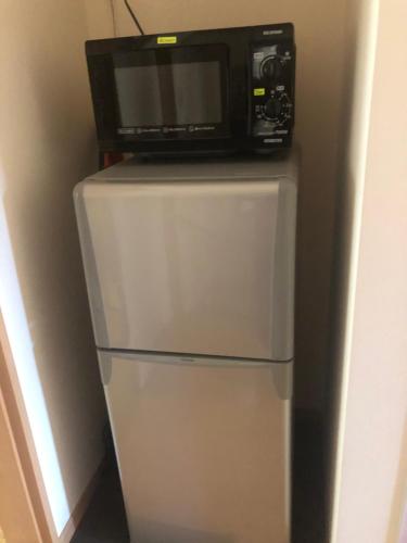 eine Mikrowelle auf einem Kühlschrank in der Unterkunft SUMIDA in Osaka