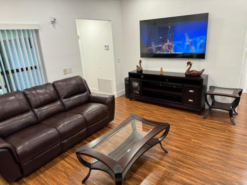 a living room with a leather couch and a flat screen tv at Sunrise 3 bed @ sawgrass mills in Sunrise