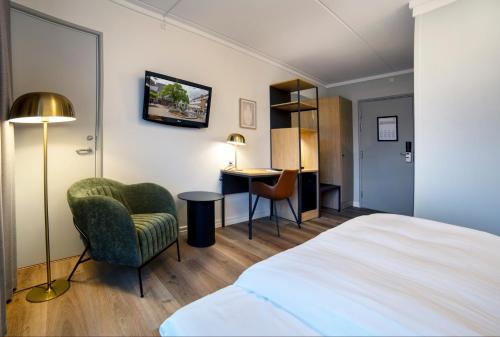 Go Hotel Herlev في هيرليف: غرفة في الفندق بسرير وكرسي ومكتب