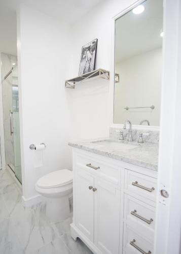 a white bathroom with a toilet and a mirror at Sunrise 3 bed @ sawgrass mills in Sunrise