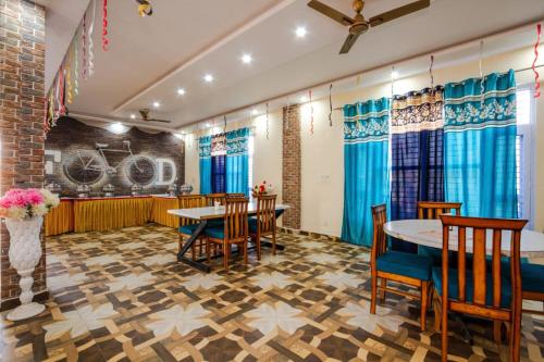 - un restaurant avec des tables, des chaises et des rideaux bleus dans l'établissement Hotel Roop, à Sundarnagar