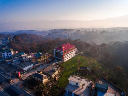 un bâtiment avec un toit rouge dans une ville dans l'établissement Hotel Roop, à Sundarnagar