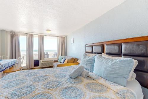 um quarto com uma cama grande e uma janela grande em Pirates Cove Unit G22 em Daytona Beach