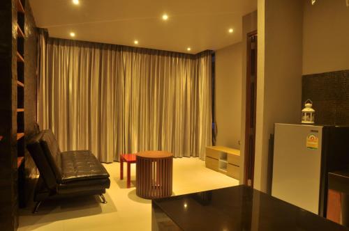 a living room with a refrigerator and a chair at Pony Hill Villa in Bophut