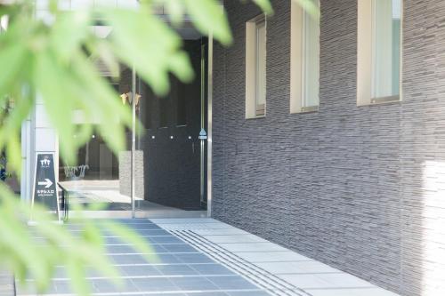 una puerta abierta de un edificio de ladrillo en Sanco Inn Nagoya Fushimi, en Nagoya