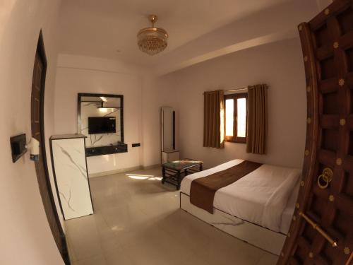 een slaapkamer met een bed en een spiegel bij Marcol a countryside villa in Udaipur