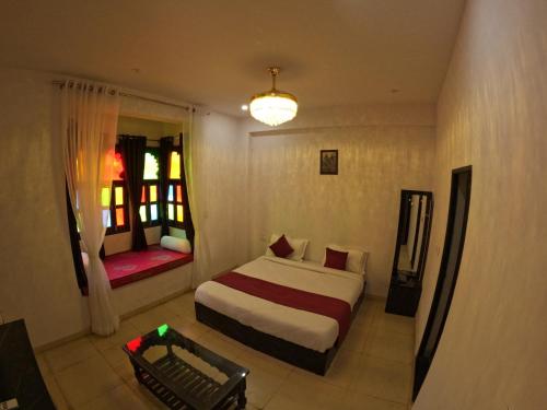 Habitación de hotel con cama y ventana en Marcol a countryside villa, en Udaipur
