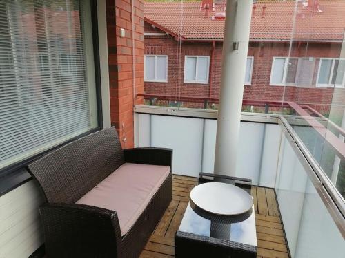 a balcony with a couch and a table on a balcony at two-room apartment midle in Kotka with sauna in Kotka
