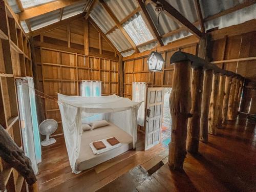 um quarto com uma cama numa casa de madeira em Eve house koh kood em Ko Kood