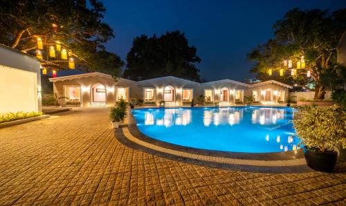 a large swimming pool in a courtyard at night at Treebo Trend Greenland Resort - Patia in Bhubaneshwar