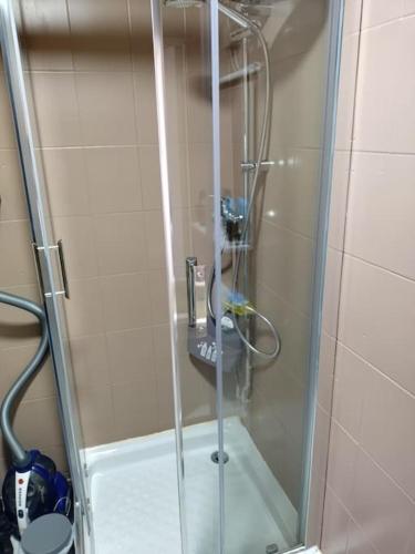 une douche avec une porte vitrée dans une salle de bain dans l'établissement Spacieux studio confortable, à Anzin