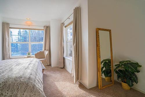 a bedroom with a mirror and a bed and a window at Ballard's Townhome with office & walk score 98 in Seattle