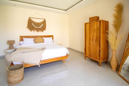 a bedroom with a bed and a wooden cabinet at Brand New Villa - BEST Location Near City Center and Beach! in Kerobokan