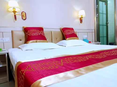 a bedroom with a large bed with red pillows at Qufu Garden Hotel in Qufu