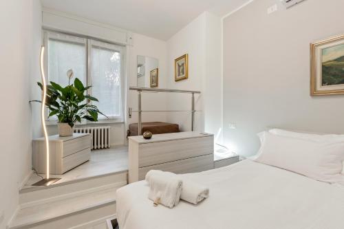ein weißes Schlafzimmer mit einem Bett und einem Fenster in der Unterkunft BWR - Appartamenti in zona Sempione-Tre torri, via Alberti in Mailand