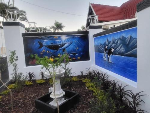 a wall with two paintings on it with a plant at Orca Estate Guesthouse Self-catering Accommodation in Durban