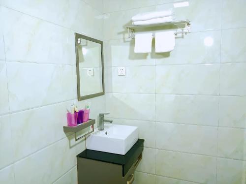 a white bathroom with a sink and a mirror at Qufu Garden Hotel in Qufu