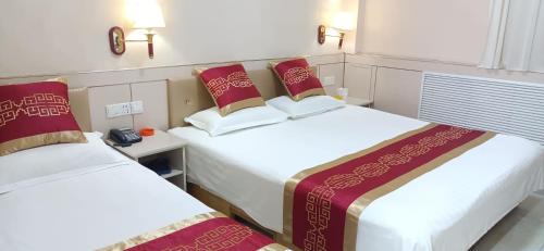 a hotel room with two beds and a telephone at Qufu Garden Hotel in Qufu