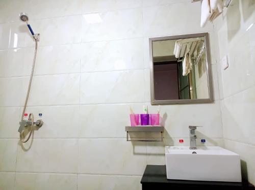 a white bathroom with a sink and a mirror at Qufu Garden Hotel in Qufu