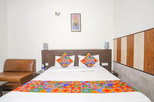 een slaapkamer met een bed met een kleurrijke deken erop bij FabHotel Prashant Palace in Agra