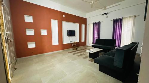 a living room with a couch and a tv at Western Ghats Holiday Home in Kalpetta