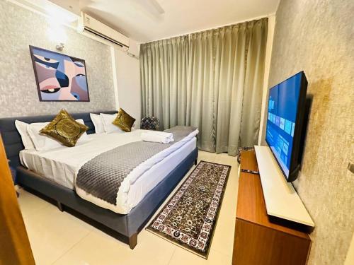 een slaapkamer met een bed en een flatscreen-tv bij Celestial Chic Suite With Swimming Pool in Lucknow