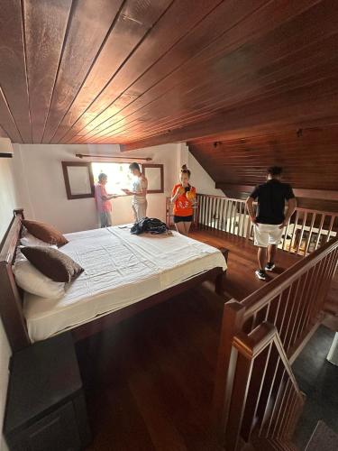 a bedroom with a large bed with people walking up the stairs at Neem Tree Ambalangoda in Ambalangoda