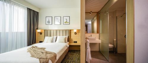 a hotel room with a bed and a bathroom at Be One Hotel in Sofia