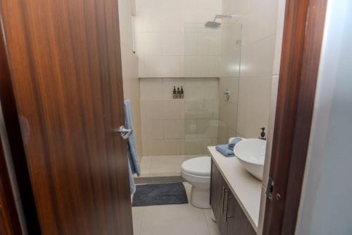 a bathroom with a toilet and a sink and a shower at Villa Paraiso do Mar in Jacó