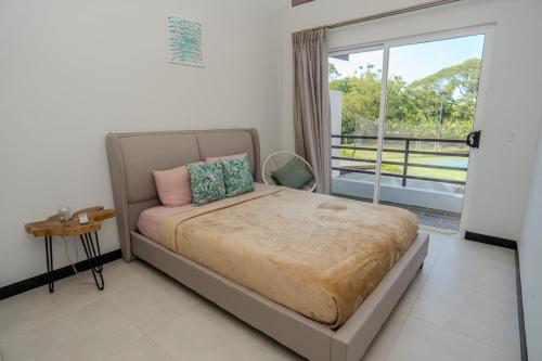 a bedroom with a bed and a large window at Villa Paraiso do Mar in Jacó